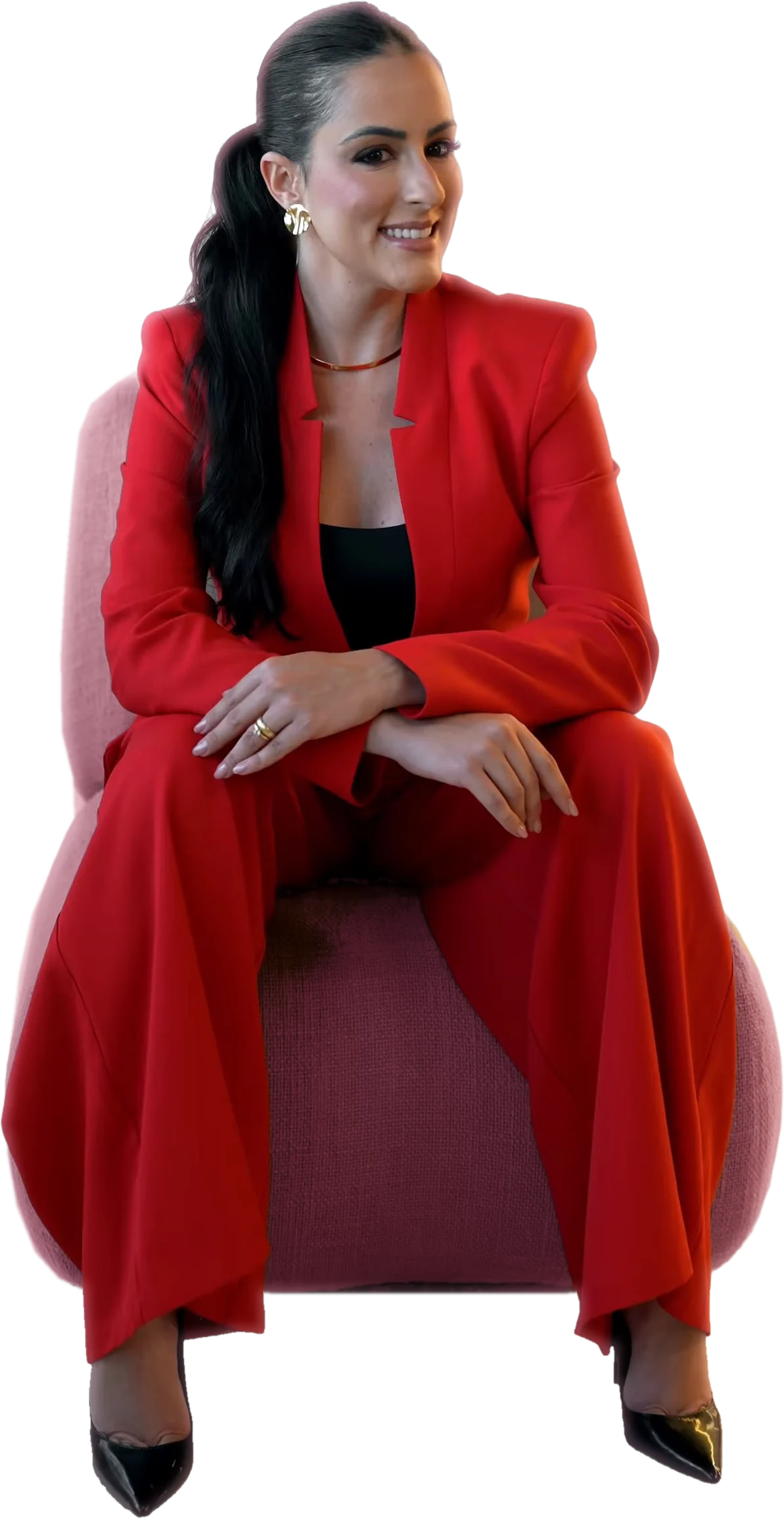 Dra. Mallu Cerutti de terno vermelho, sentada numa poltrona, sorrindo