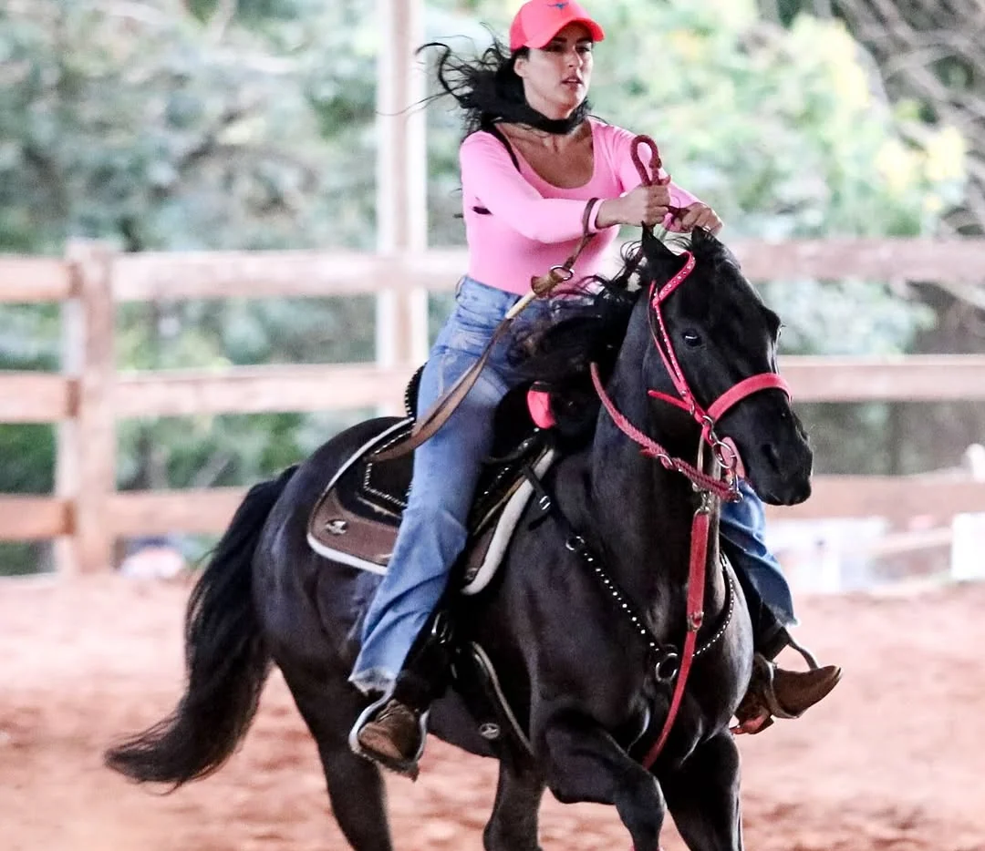 Ela fazendo a curva a cavalo, com o cabelo ao vento